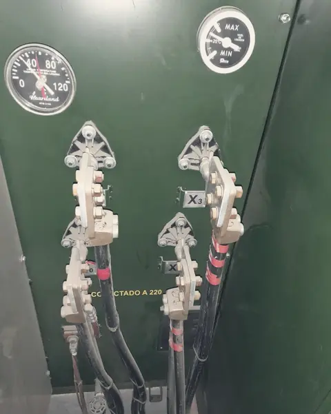 Boquillas y conectores dentro del gabinete verde de un transformador tipo pedestal