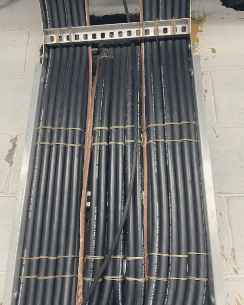 Cables negros alineados en una charola, amarrados a intervalos