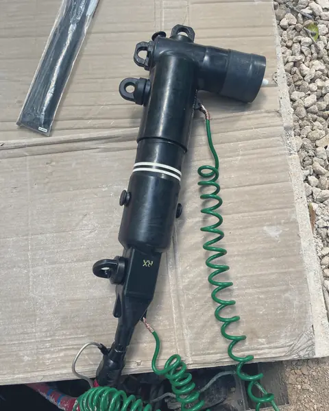Codo conector de media tensión con su cable de tierra, sobre cartón en obra