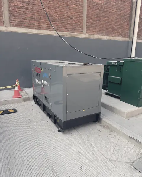 Planta de emergencia en su gabinete, junto a un transformador tipo pedestal