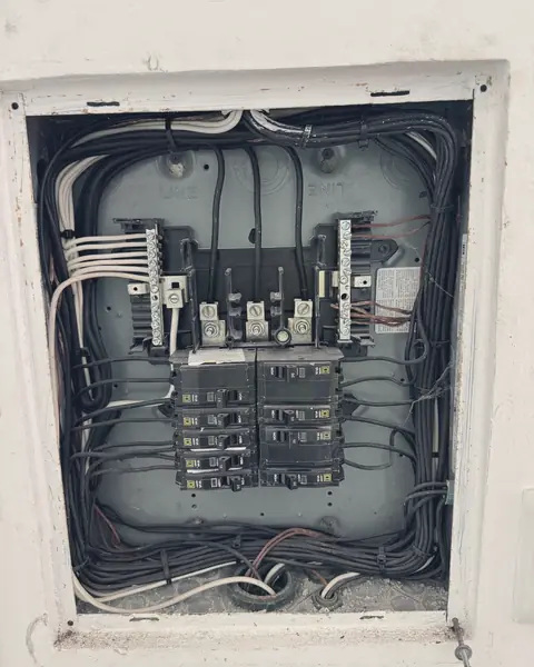 Centro de carga empotrado con interruptores y cableado peinado