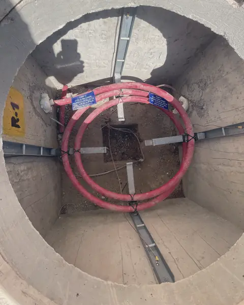 Registro circular de concreto con cables rojos de media tensión enrollados en anillo