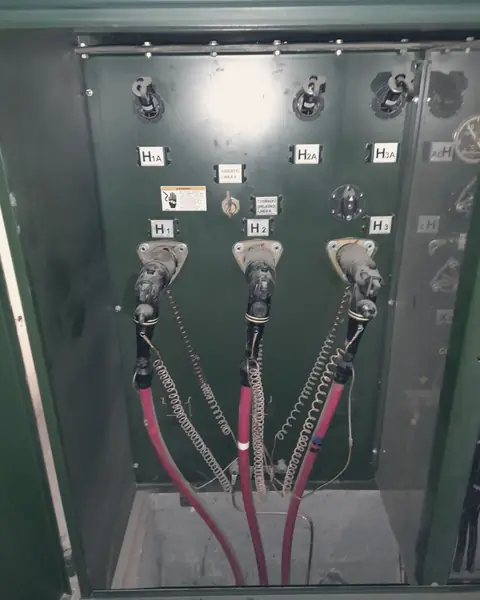 Terminales de media tensión con cables rojos dentro de un transformador